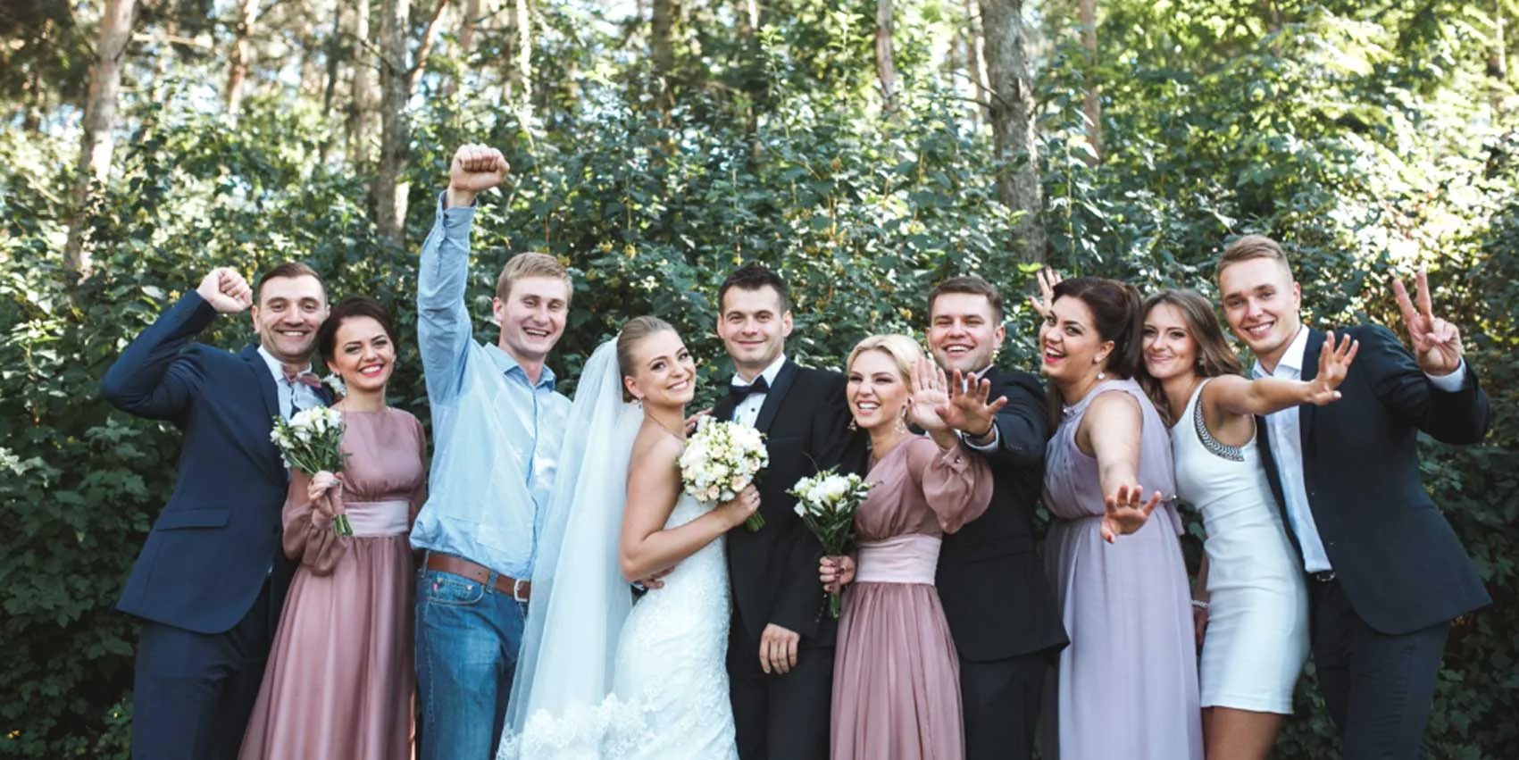 Newlyweds surrounded by their loved ones, bouquets in hand