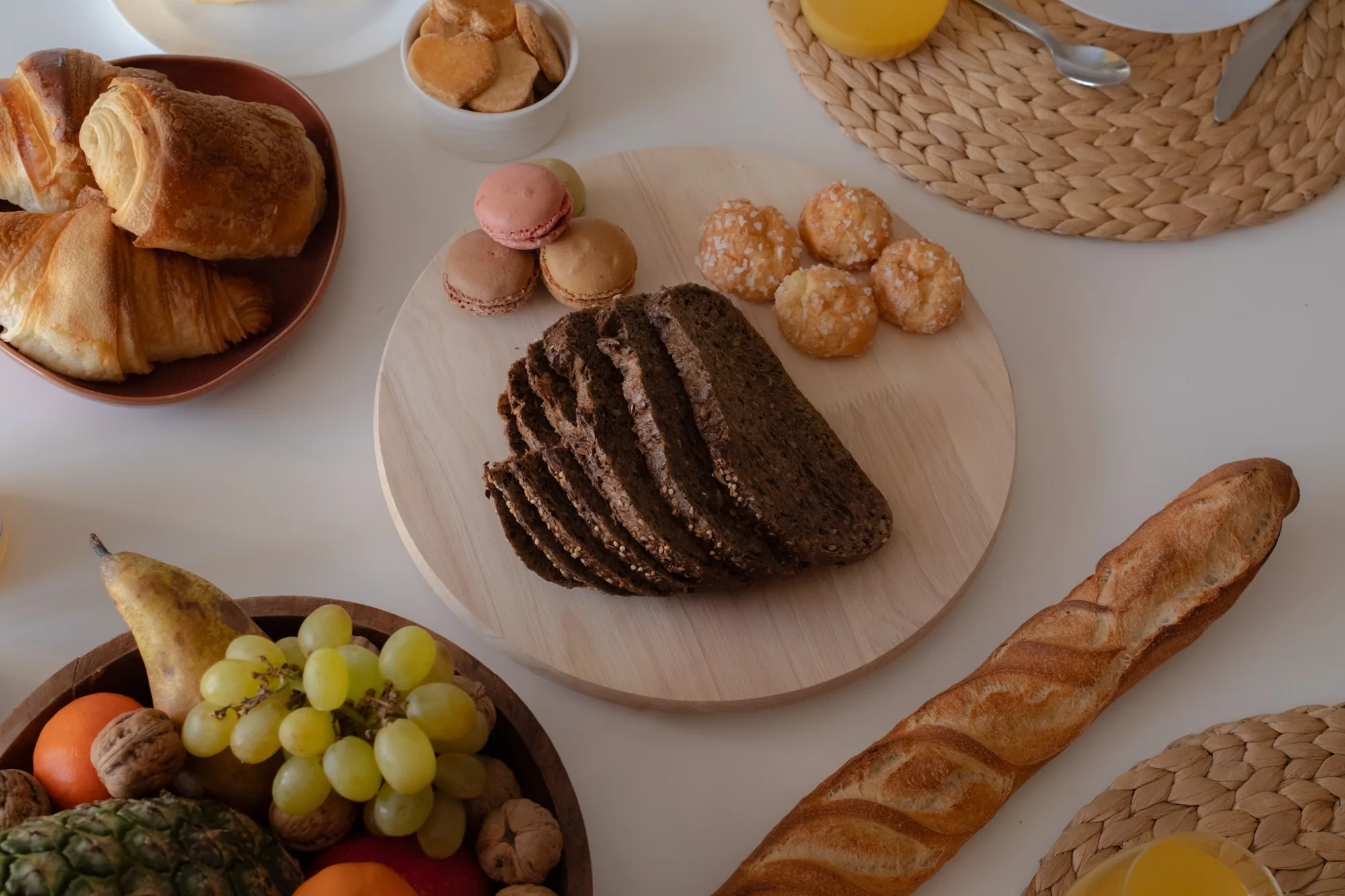 Breakfast on the table: pastries, bread, fruit and orange juice