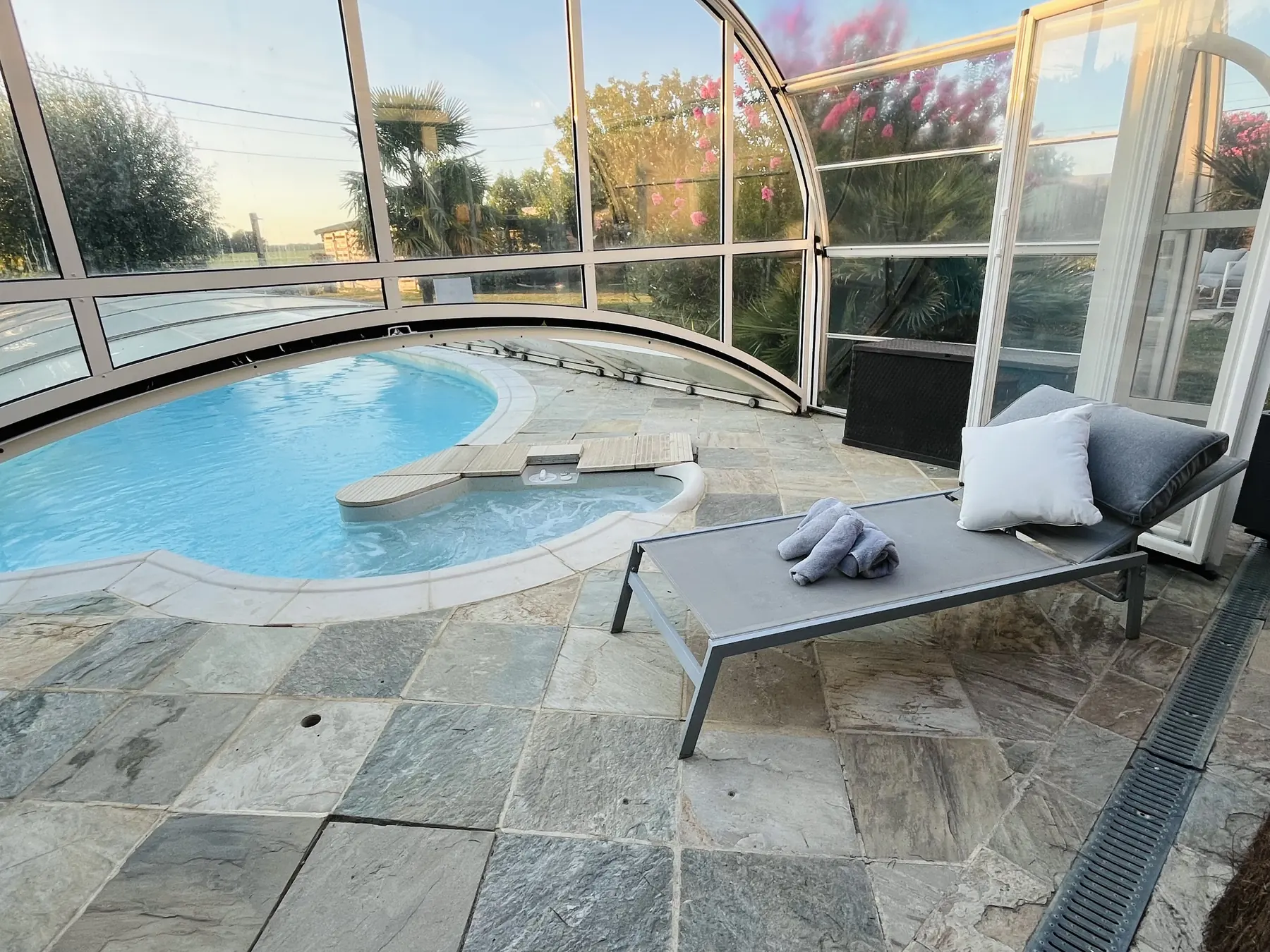 Piscine sous son abri, transats et plantes