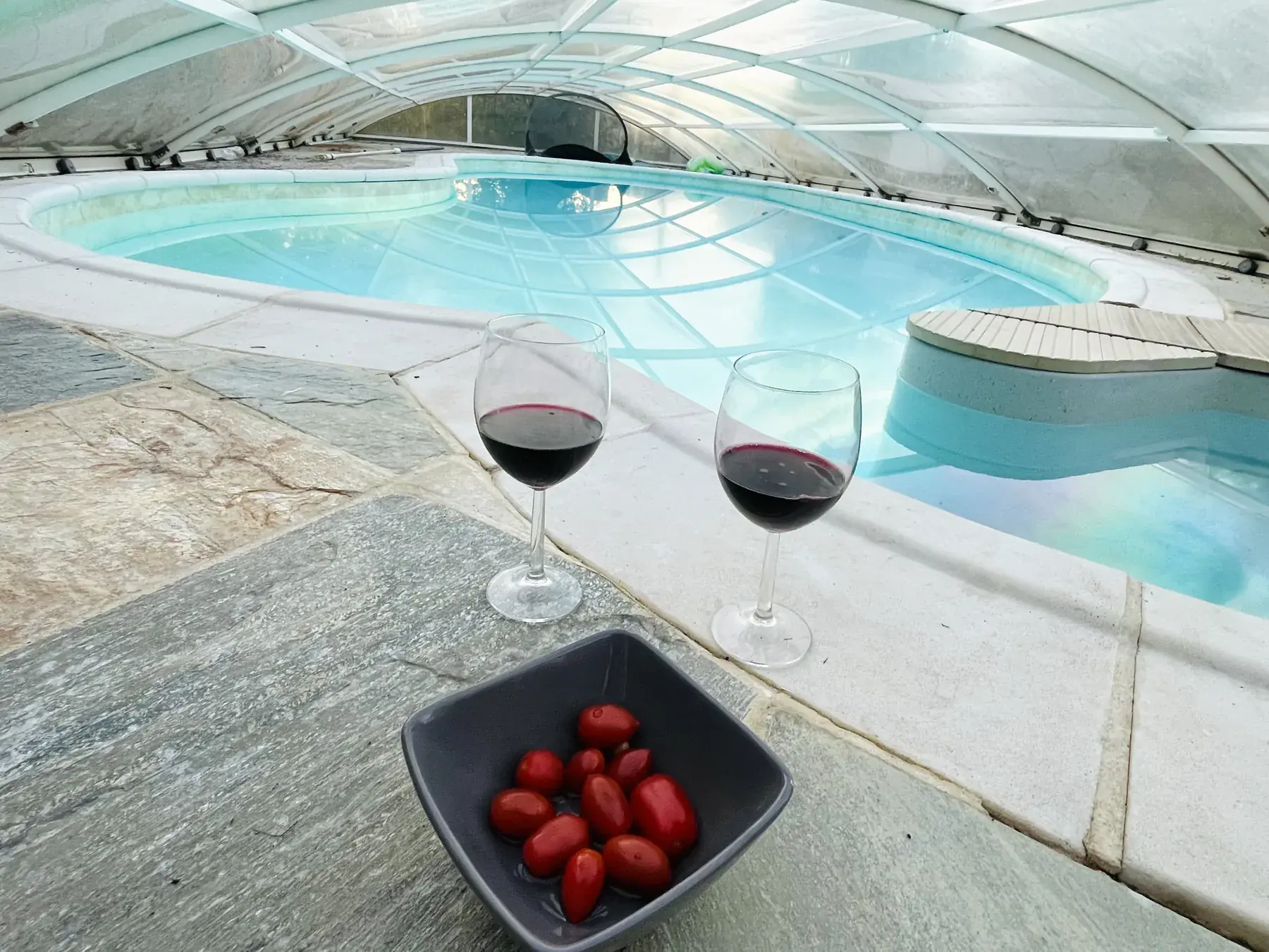 Glasses of wine and strawberries by the indoor pool