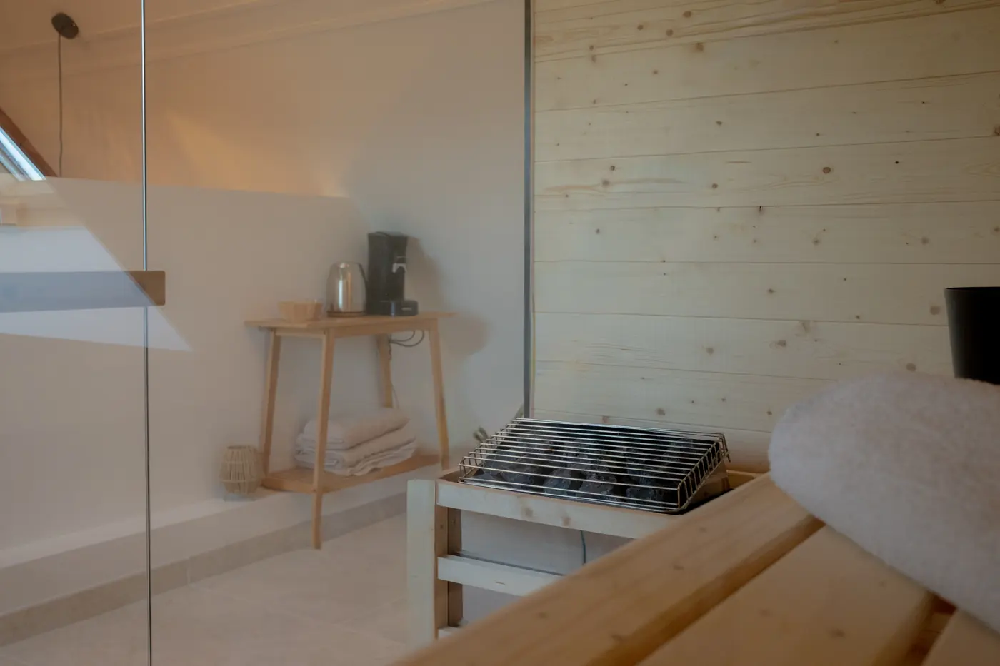 Inside the wooden sauna: stove, stones and folded towels